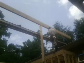 Carpenter setting a ridge beam over a new addition frame — Ice Dam Removal by Roofing Brothers in Seabeck