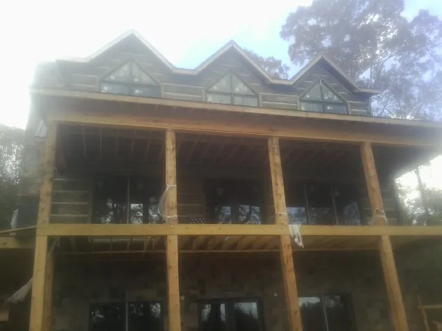 Dormers and porch framing on a large log home under construction — Roof Coating work by our crew in Seabeck